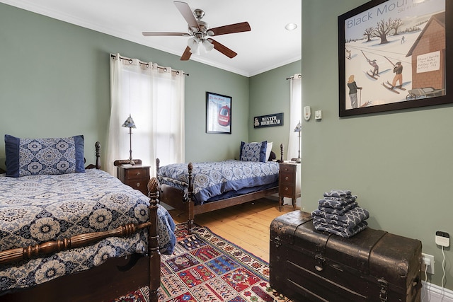 bedroom featuring hardwood / wood-style floors, ceiling fan, and ornamental molding