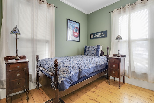 bedroom featuring light wood-type flooring and ornamental molding