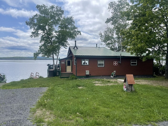 back of house featuring a water view and a yard