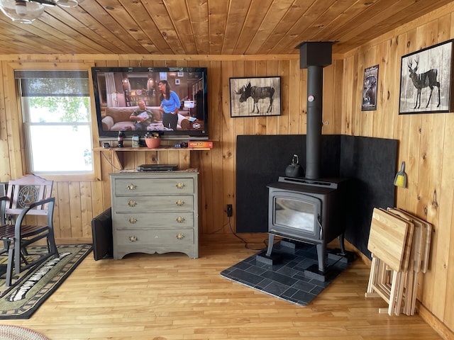161 Burnt Lndg Unit T16 R5, Wels, ME 04779 - interior space with a wood stove, light hardwood / wood-style flooring, and wooden walls