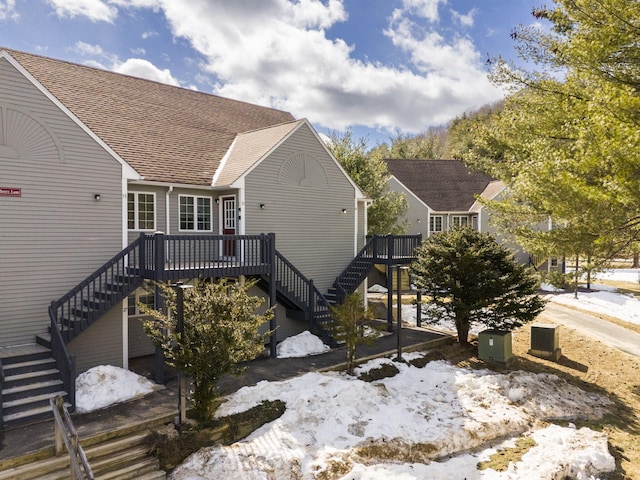 snow covered property with a wooden deck