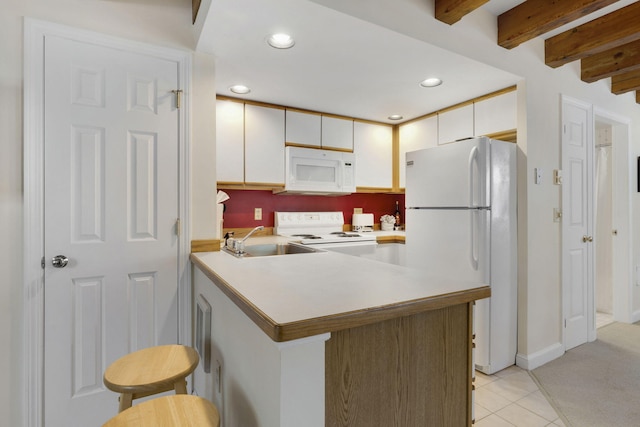 kitchen featuring kitchen peninsula, white appliances, white cabinets, light carpet, and a kitchen bar