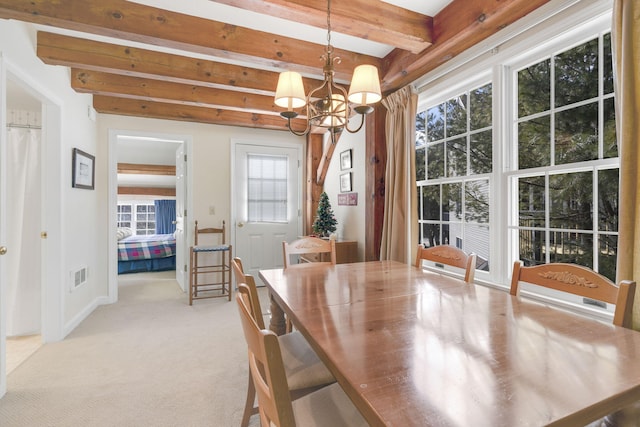 unfurnished dining area with a notable chandelier, light carpet, and beamed ceiling