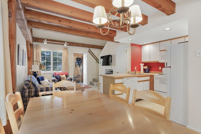 dining space with a notable chandelier, sink, and beam ceiling