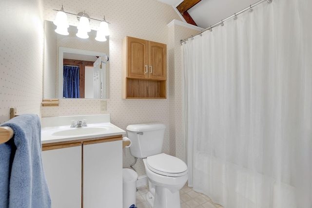 bathroom with toilet, vaulted ceiling, large vanity, and tile flooring