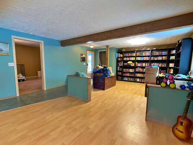 home office featuring beamed ceiling, tile floors, and a textured ceiling