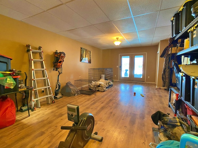 workout area with french doors, wood-type flooring, and a drop ceiling