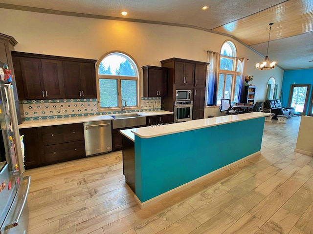 kitchen with stainless steel appliances, a healthy amount of sunlight, light hardwood / wood-style floors, and tasteful backsplash