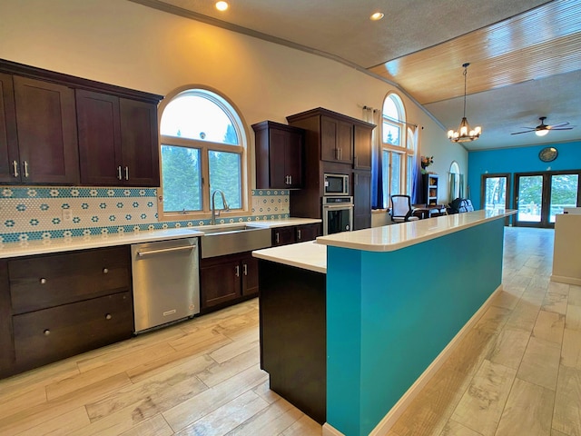 kitchen with light hardwood / wood-style flooring, backsplash, appliances with stainless steel finishes, sink, and pendant lighting