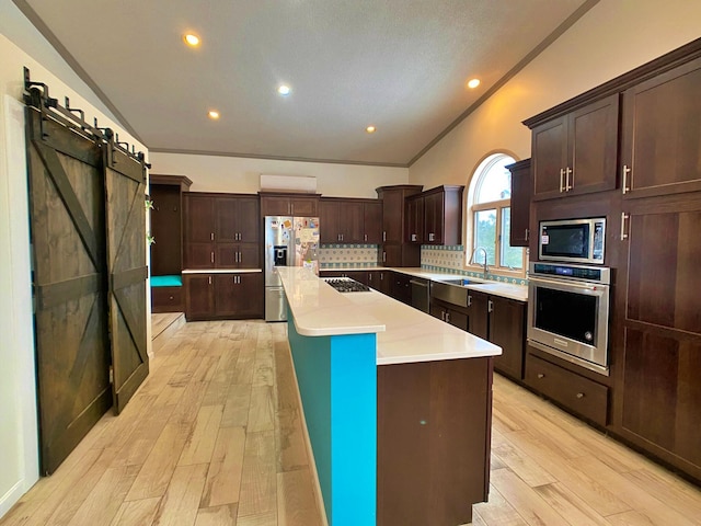 kitchen with a kitchen island, stainless steel appliances, light hardwood / wood-style floors, and backsplash
