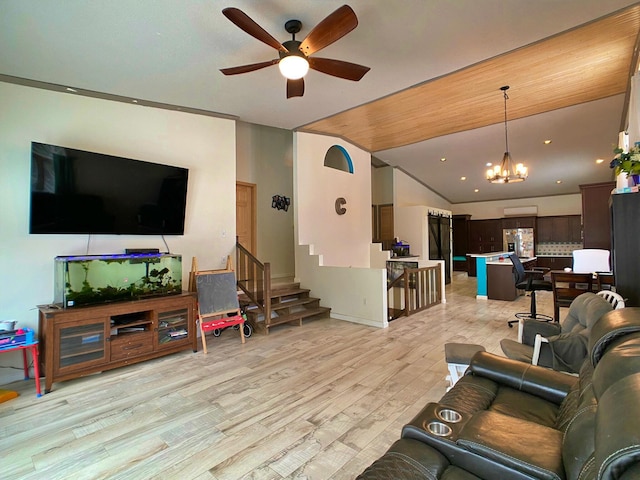 living room with vaulted ceiling, light hardwood / wood-style flooring, and ceiling fan with notable chandelier