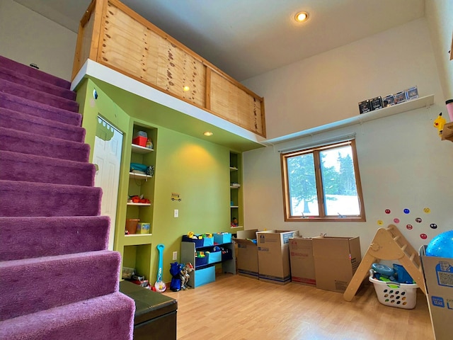rec room with built in features and hardwood / wood-style flooring