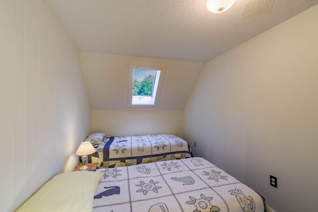 bedroom featuring vaulted ceiling and a textured ceiling