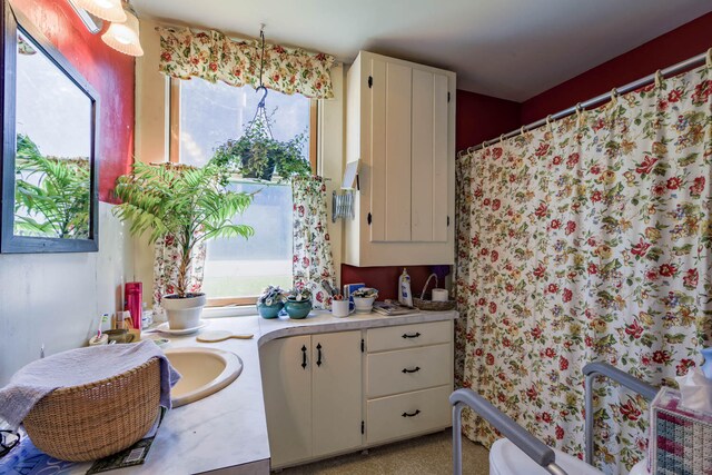 kitchen featuring a wealth of natural light and white cabinetry