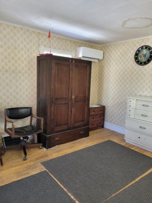 interior space with a wall mounted air conditioner, ornamental molding, and light wood-type flooring