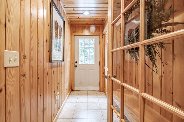 entryway with wood walls, wood ceiling, and light tile patterned flooring