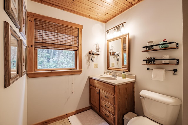 bathroom featuring baseboards, toilet, wooden ceiling, tile patterned floors, and vanity