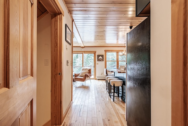 hall with light wood-style floors, a baseboard radiator, and wood ceiling