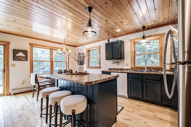 kitchen with dishwasher, a center island, freestanding refrigerator, light wood-style floors, and a sink