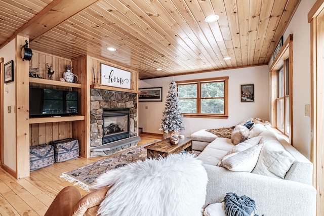 living area with a stone fireplace, wooden ceiling, recessed lighting, built in features, and hardwood / wood-style floors