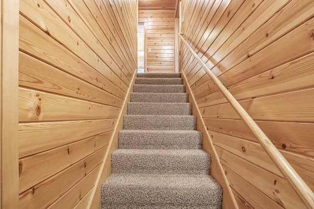 staircase featuring wood walls and wooden ceiling