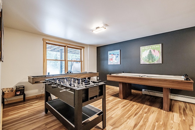 playroom with light wood-style flooring, baseboards, and baseboard heating