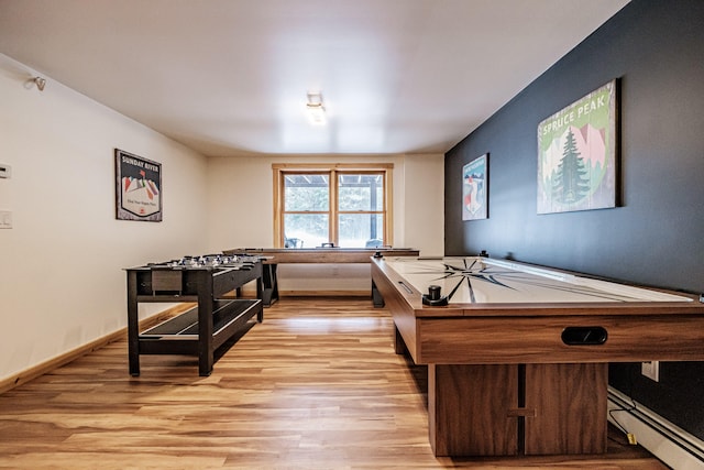 playroom with a baseboard radiator, baseboards, and light wood finished floors