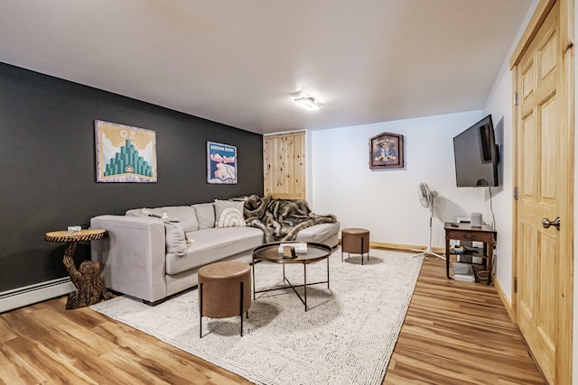 living room with light wood-type flooring, baseboards, and a baseboard radiator