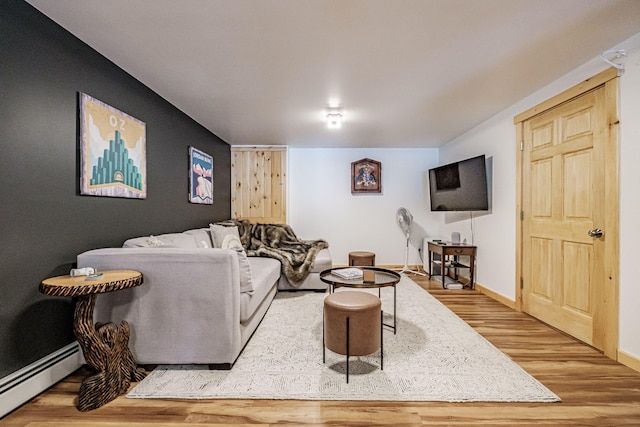 living room with a baseboard heating unit, baseboards, and wood finished floors