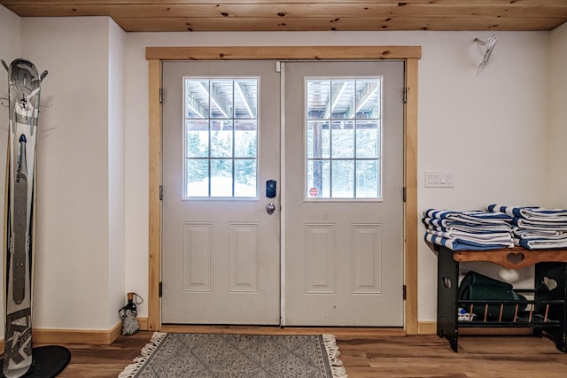 doorway with light wood-type flooring, wood ceiling, and baseboards