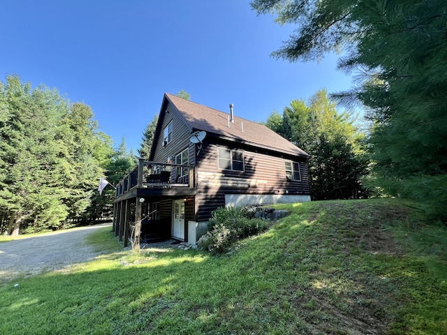 view of property exterior featuring a yard and a wooden deck