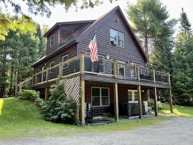 exterior space featuring faux log siding, a deck, and a lawn