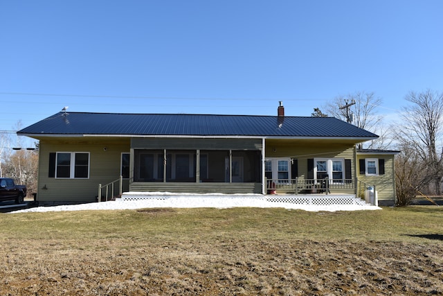 rear view of property with a yard and a sunroom