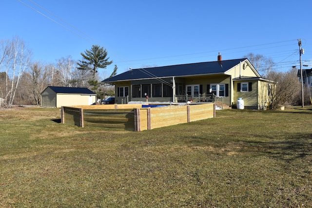 back of house with an outdoor structure and a lawn