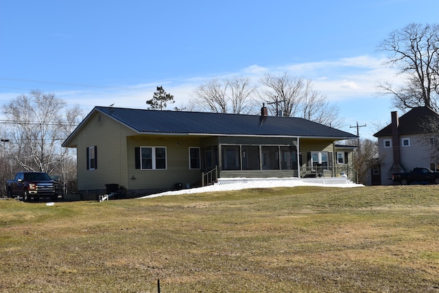 back of property featuring a yard and a sunroom