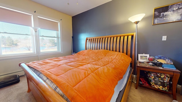 bedroom with light carpet and a baseboard heating unit