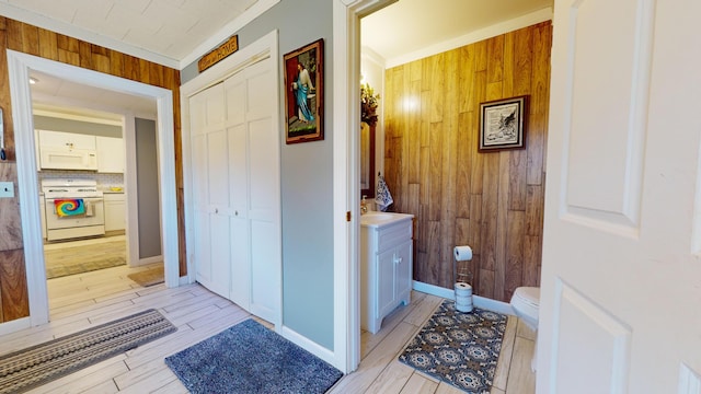 bathroom with vanity, toilet, wooden walls, crown molding, and hardwood / wood-style flooring