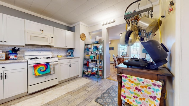 kitchen with white appliances, ornamental molding, white cabinets, light hardwood / wood-style floors, and tasteful backsplash