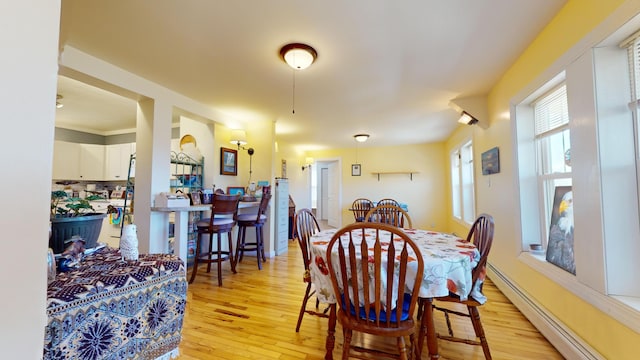 dining room featuring a baseboard heating unit and light wood-type flooring