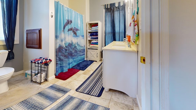 bathroom featuring toilet, tile floors, and vanity