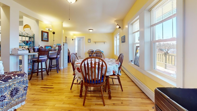 dining room with plenty of natural light, light hardwood / wood-style floors, and baseboard heating