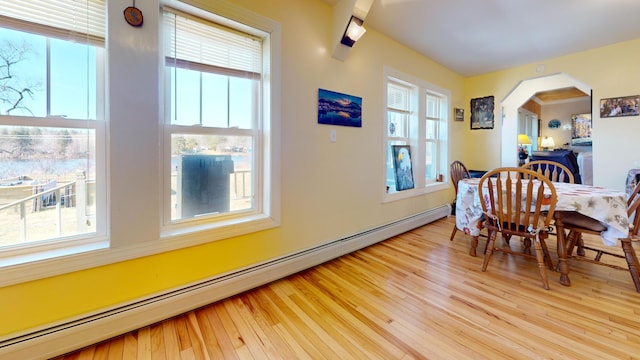 dining area with a baseboard heating unit and light hardwood / wood-style flooring