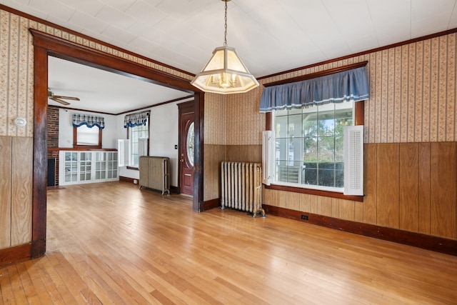 unfurnished room featuring ornamental molding, hardwood / wood-style floors, and radiator