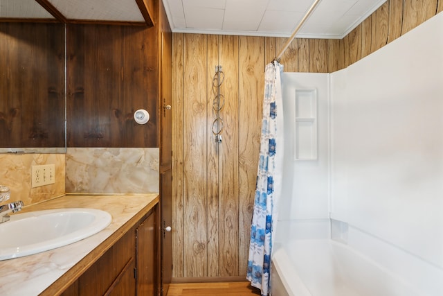 bathroom with wood walls, shower / tub combo, hardwood / wood-style floors, and vanity