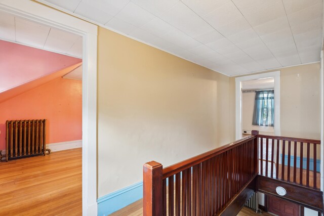 stairs with radiator heating unit and hardwood / wood-style flooring