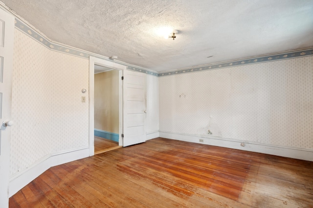 spare room with hardwood / wood-style flooring and a textured ceiling