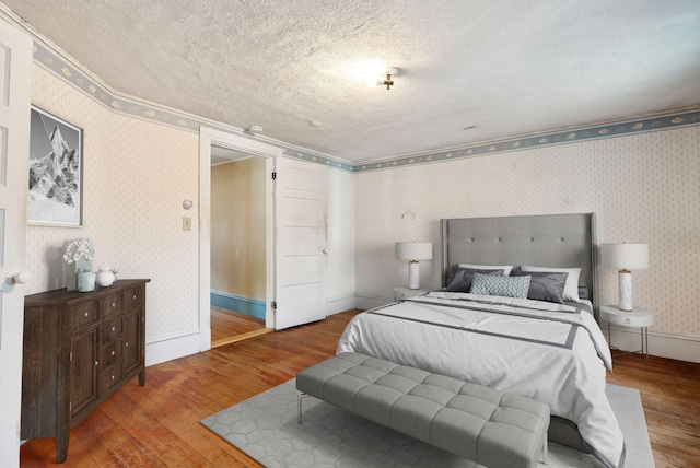 bedroom with hardwood / wood-style floors and a textured ceiling