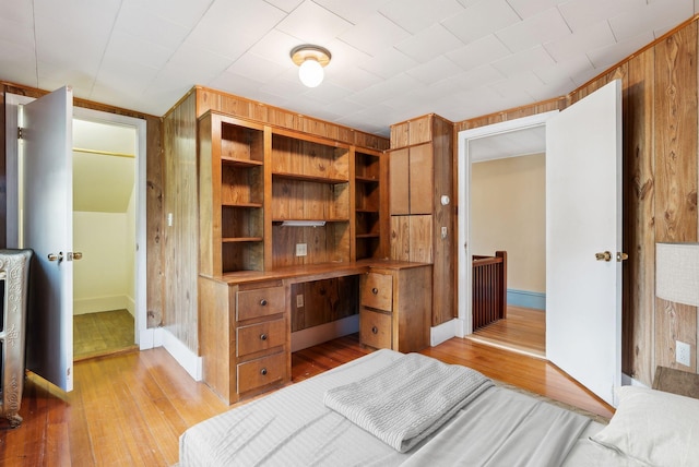 bedroom featuring wood walls and light hardwood / wood-style flooring