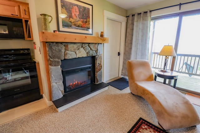 sitting room with light carpet and a stone fireplace