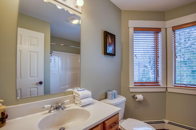 bathroom featuring a baseboard heating unit, vanity, a wealth of natural light, and walk in shower